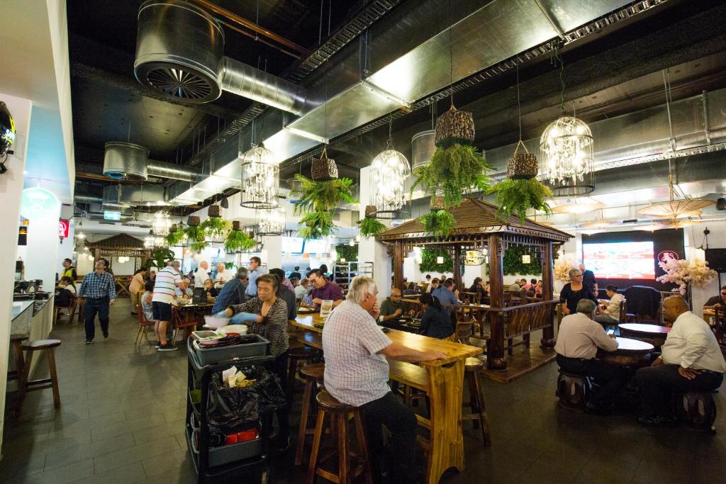 a group of people sitting at tables in a restaurant at Cozy Urban Chinatown Escape Adelaide CBD - Free parking in Adelaide