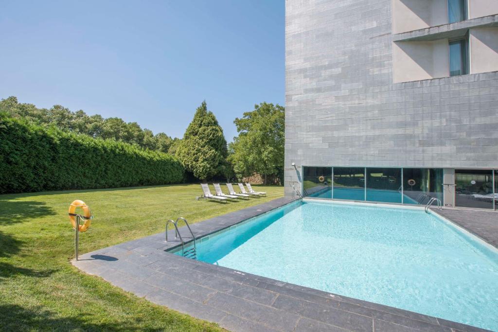 una piscina en un patio junto a un edificio en NH Collection Santiago de Compostela en Santiago de Compostela