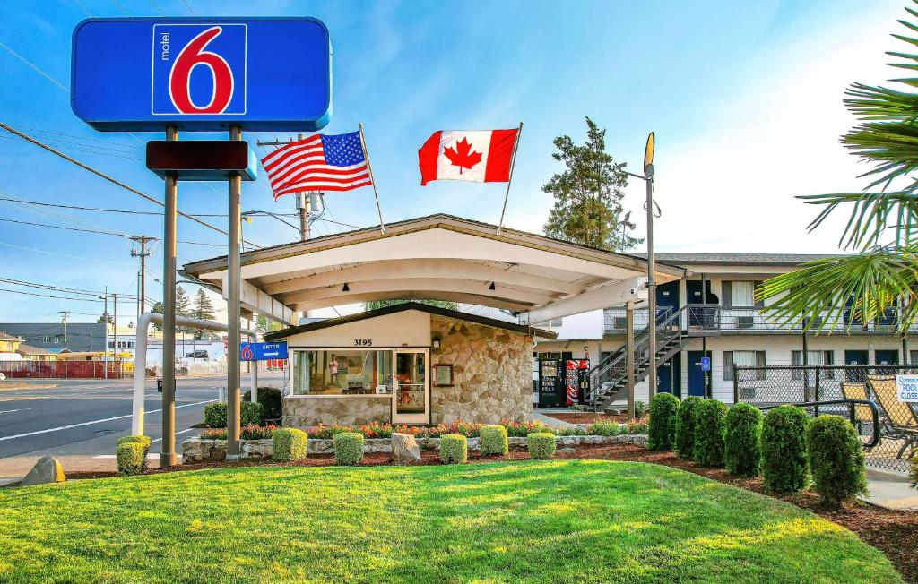 a gas station with two canadian flags on top of it at Motel 6-Salem, OR - Expo Center in Salem