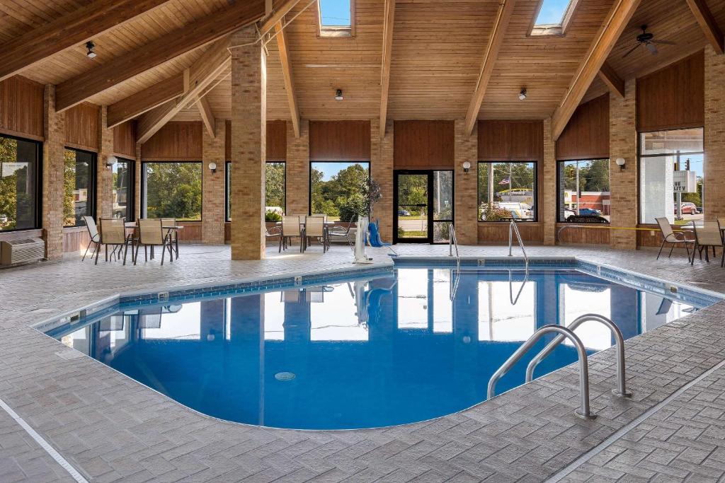 a large swimming pool in a large building with tables and chairs at Quality Inn Ashland I 71 & US 250 in Ashland