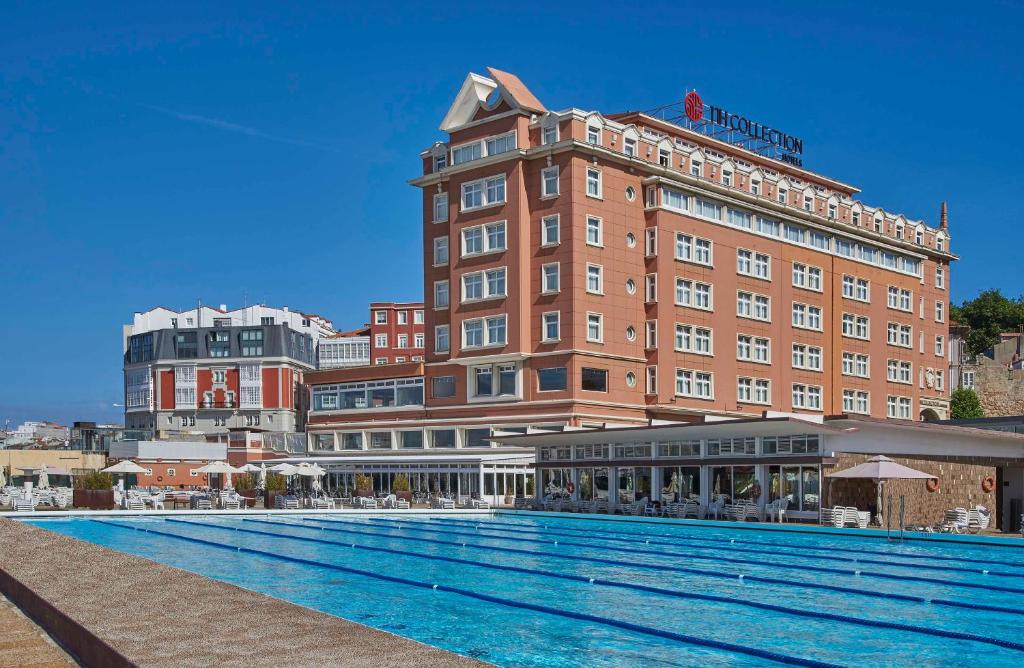 un hotel con piscina frente a un edificio en NH Collection A Coruña Finisterre en A Coruña