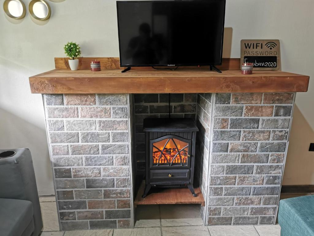 una chimenea con TV encima en Cabaña Vista Verde, en Cartago