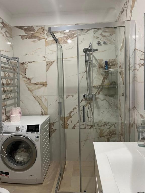 ein Bad mit einer Waschmaschine und einer Dusche in der Unterkunft La Meridian II in Barcelona