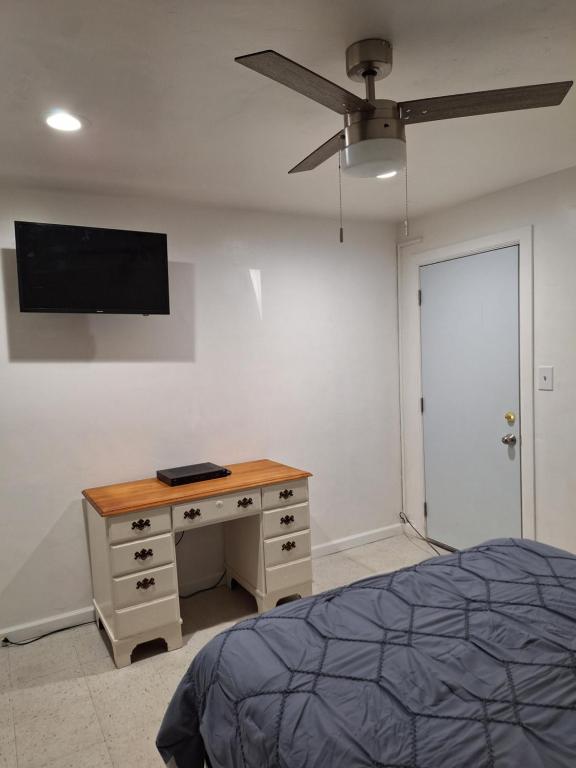 a bedroom with a desk and a tv on the wall at Garden motel in Redwood City
