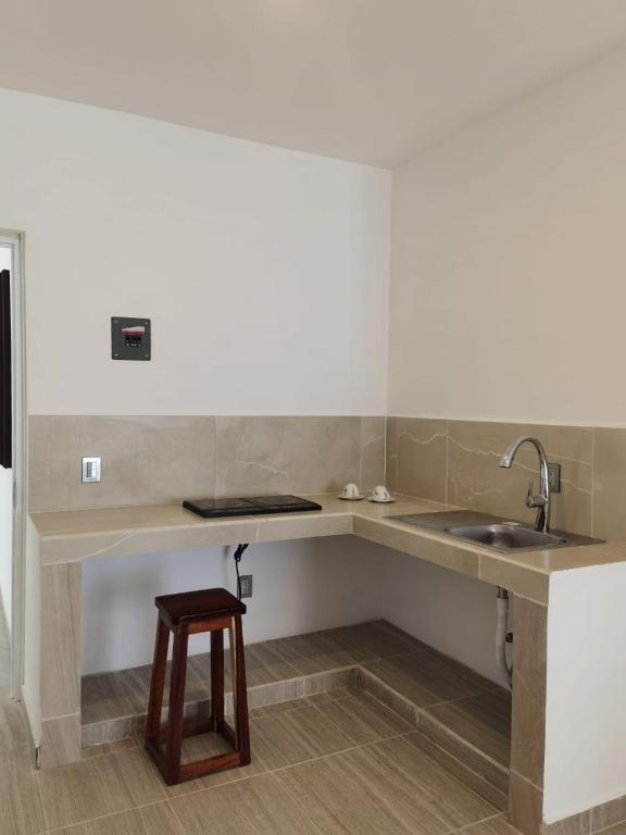 uma cozinha com um lavatório e um banco de madeira em Valparaíso Selva Maya em Leona Vicario