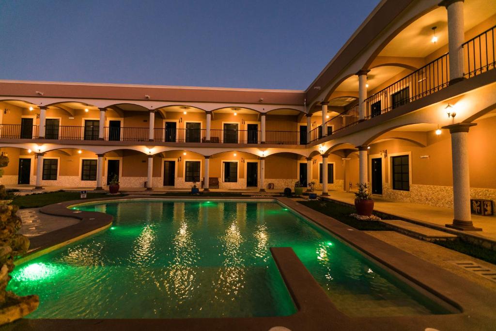 una piscina en el patio de un edificio por la noche en Hotel Los Frailes, Valladolid, Yucatán en Valladolid