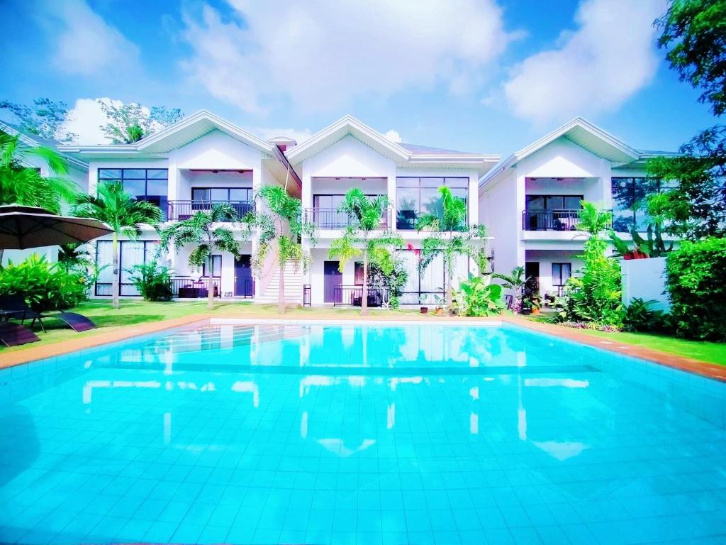 a swimming pool in front of a house at Tana Mysterious garden in Panglao