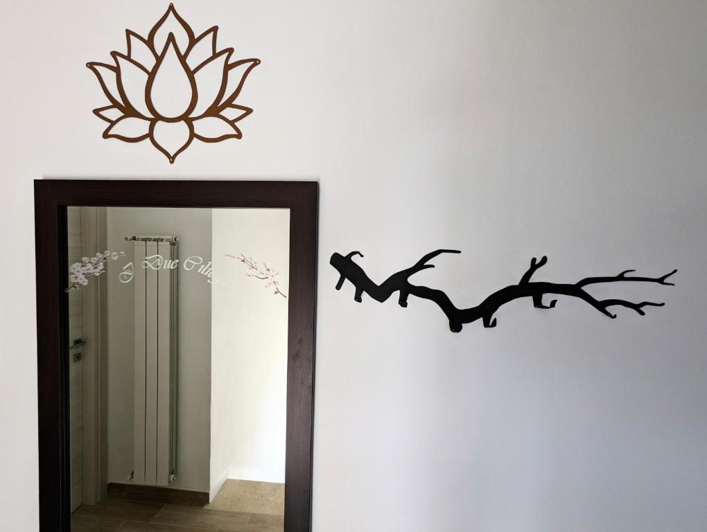 un espejo en una habitación con una flor de loto y una rama en I Due Ciliegi en Abbadia San Salvatore