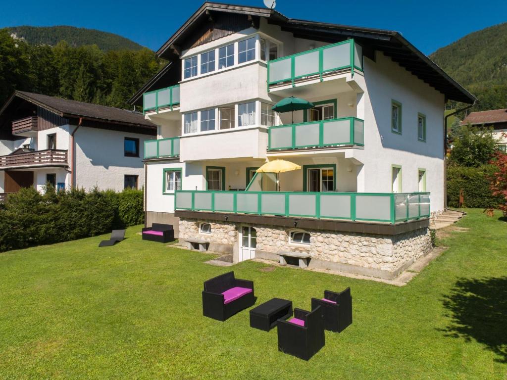 a house with a yard with chairs in front of it at Landhaus Leitzinger EG1 in St. Wolfgang