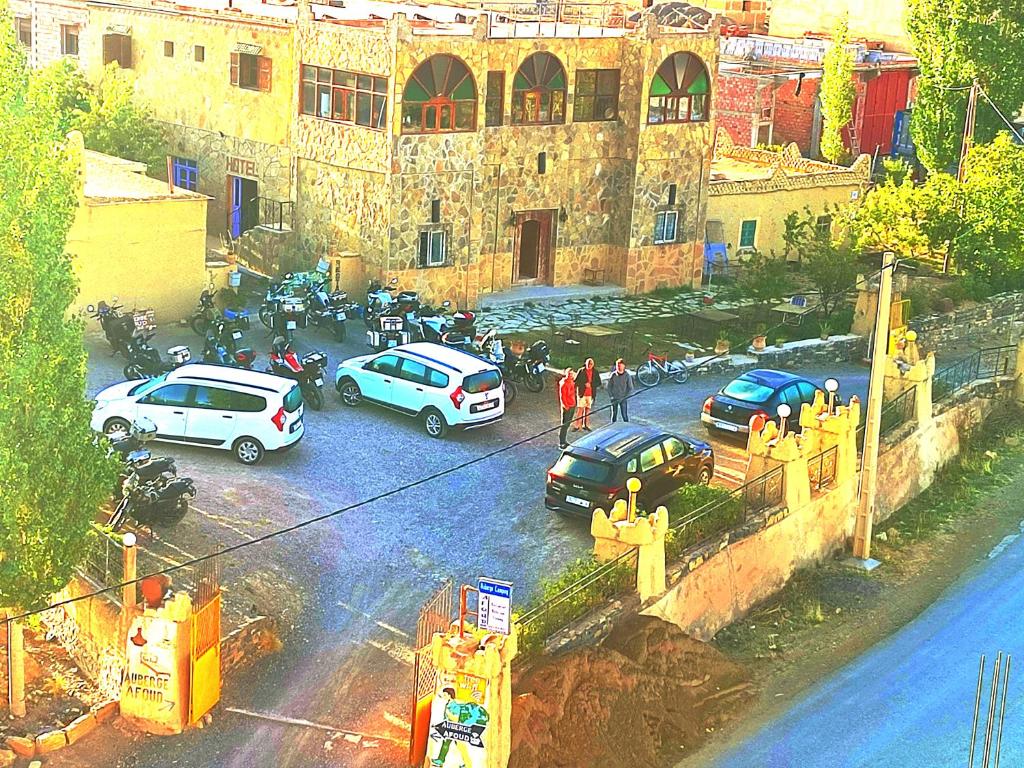 un grupo de coches estacionados frente a un edificio en Auberge restaurant Afoud, en Agoudal