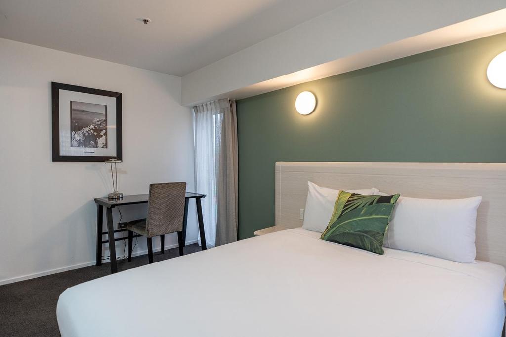 a hotel room with a bed and a desk at Mercure Wellington Central City Hotel and Apartments in Wellington