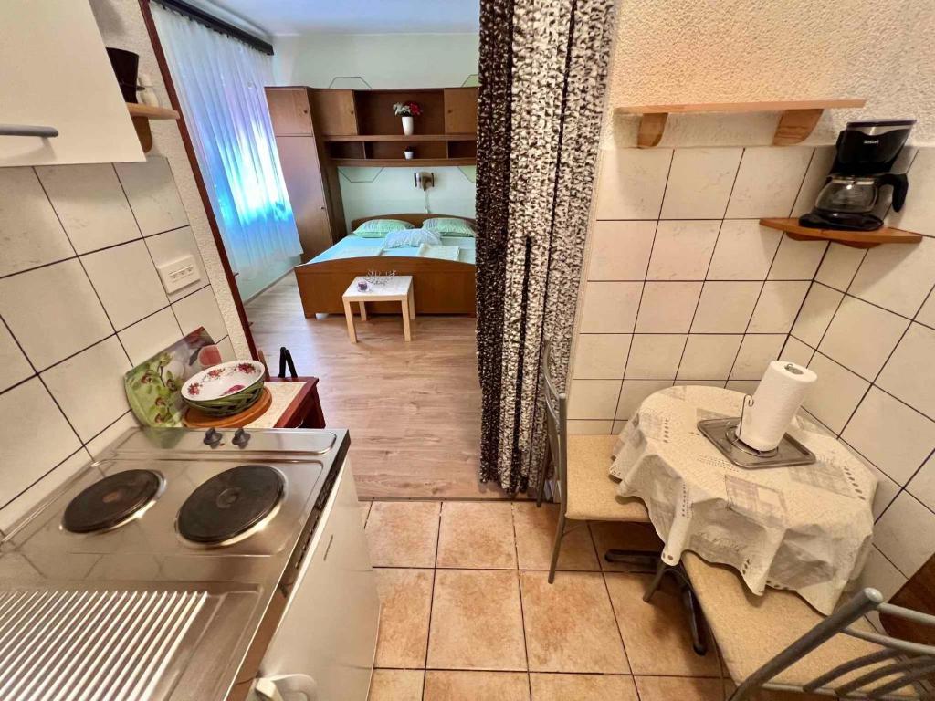 a kitchen with a stove and a room with a bed at Studio in Dramalj 45735 in Dramalj