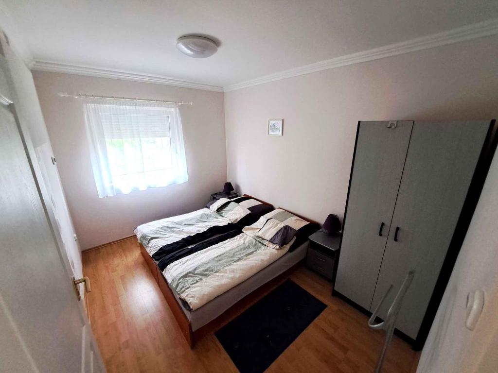 Habitación pequeña con cama y ventana en Apartments in Borgata - Nordtransdanubien 45815, en Mesteri