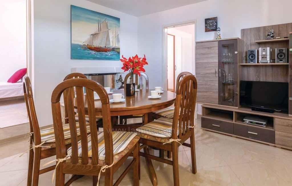 una sala da pranzo con tavolo, sedie e TV di Holiday home in Sevid 45752 a Sevid