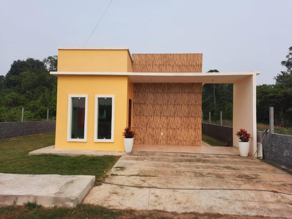 una pequeña casa amarilla en la parte superior de un campo en GIGANTE DA BELA VISTA KM 31 ESTRADA SANTA MARIA 2KM DE RAMAL, en Iranduba