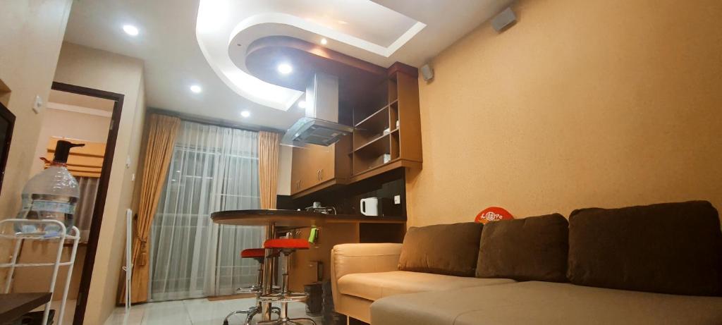 a living room with a couch and a ceiling at Classy! 2BR Medit2 West Jakarta in Jakarta