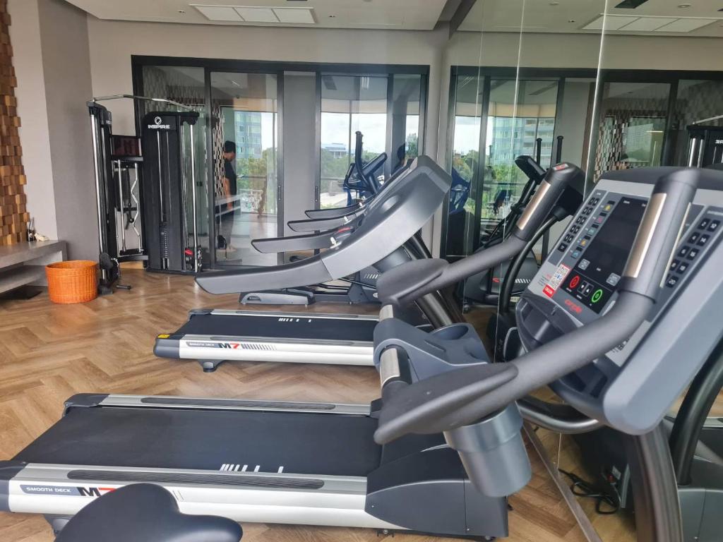 A compact gym is equipped with treadmills, elliptical machines and a cable station.