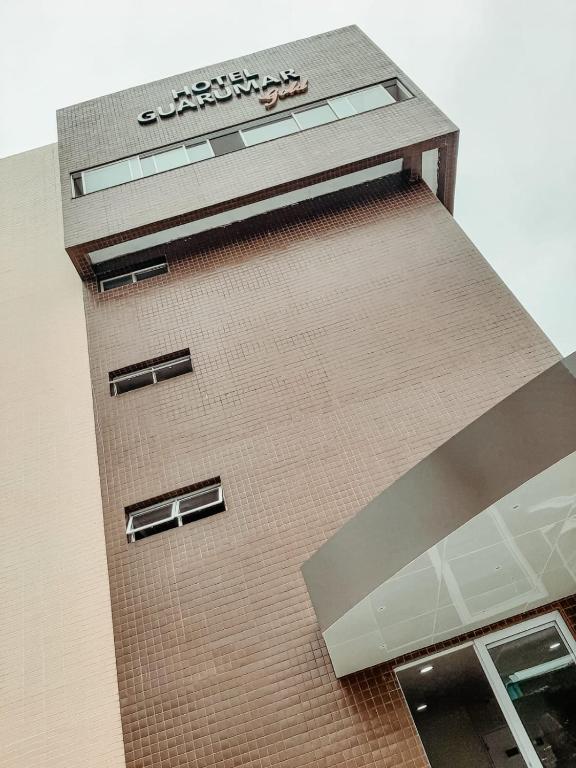 a building with a sign on the side of it at Hotel Guarumar Gold in Guarujá