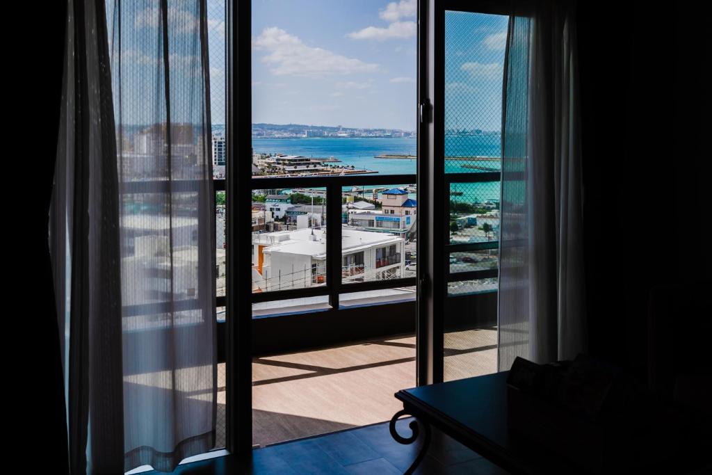 Cette chambre dispose d'une fenêtre offrant une vue sur l'océan. dans l'établissement Family Condo Chatan Hills by Coldio Premium, à Chatan