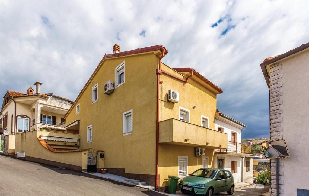 a green car parked in front of a yellow building at Apartments with parking space Crikvenica - 14631 in Crikvenica