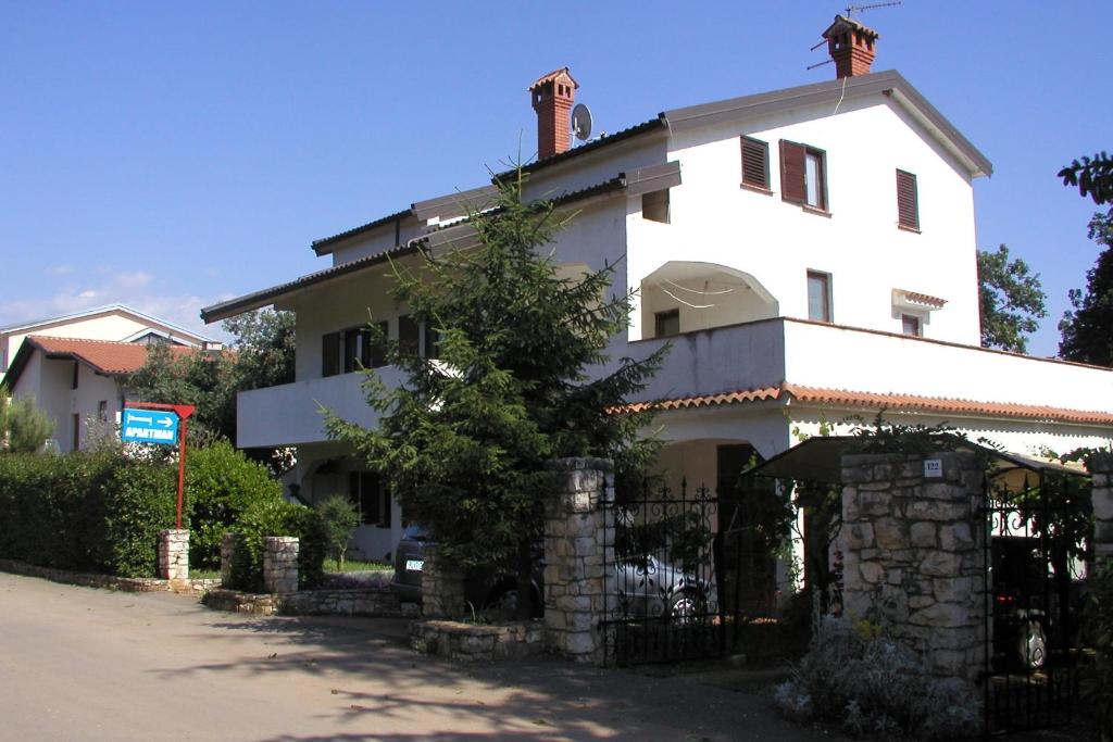 a large white house with a gate in front of it at Apartments with a parking space Karigador, Novigrad - 2534 in Karigador