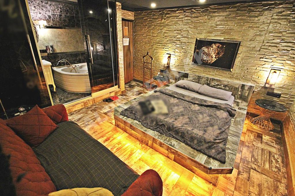 1 dormitorio con 1 cama grande y bañera en Elegant House Otel, en Ankara