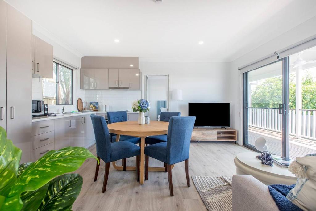 cocina y comedor con mesa y sillas en 'Redcliffe Retreat' Moreton Bay Coastal Cottage en Redcliffe