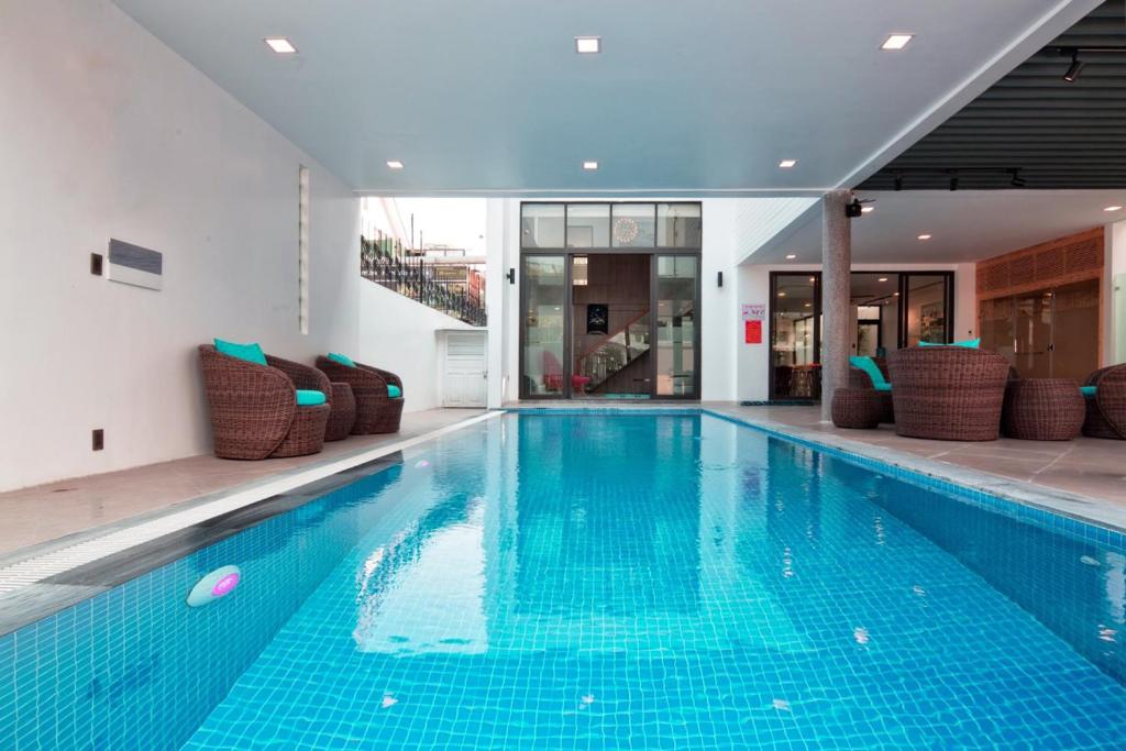 a large swimming pool with chairs in a building at Luxury Beach Villa Da Nang in Danang