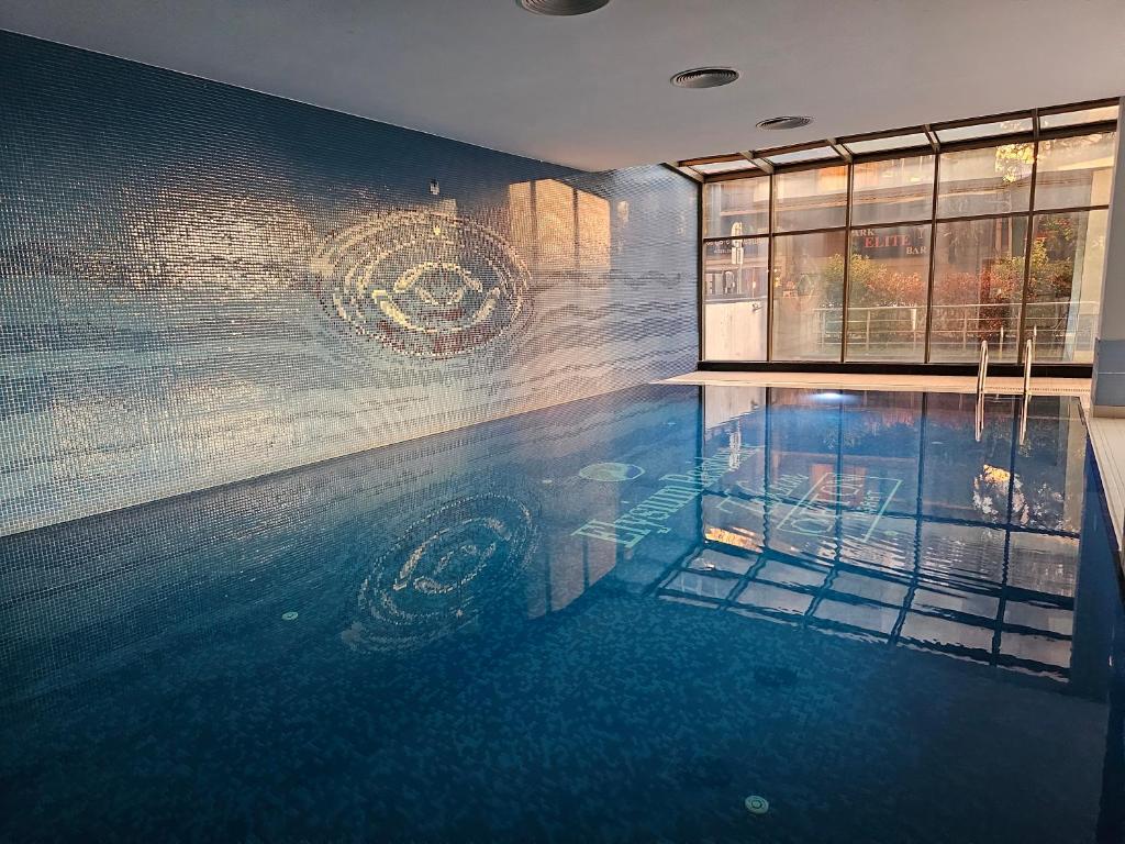 a swimming pool with a reflection in the water at TAKSiM PERFECT RESiDENCE, 3 BEDROOMS, 140 M2, POOL GYM SAUNA ACCESS in Istanbul