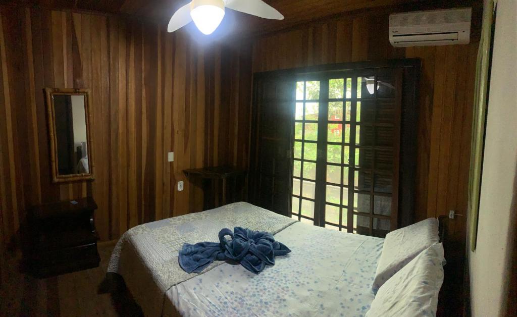 a bedroom with a bed with a blue bow on it at Pousada D'Aconchego Nova Brasilia in Ilha do Mel
