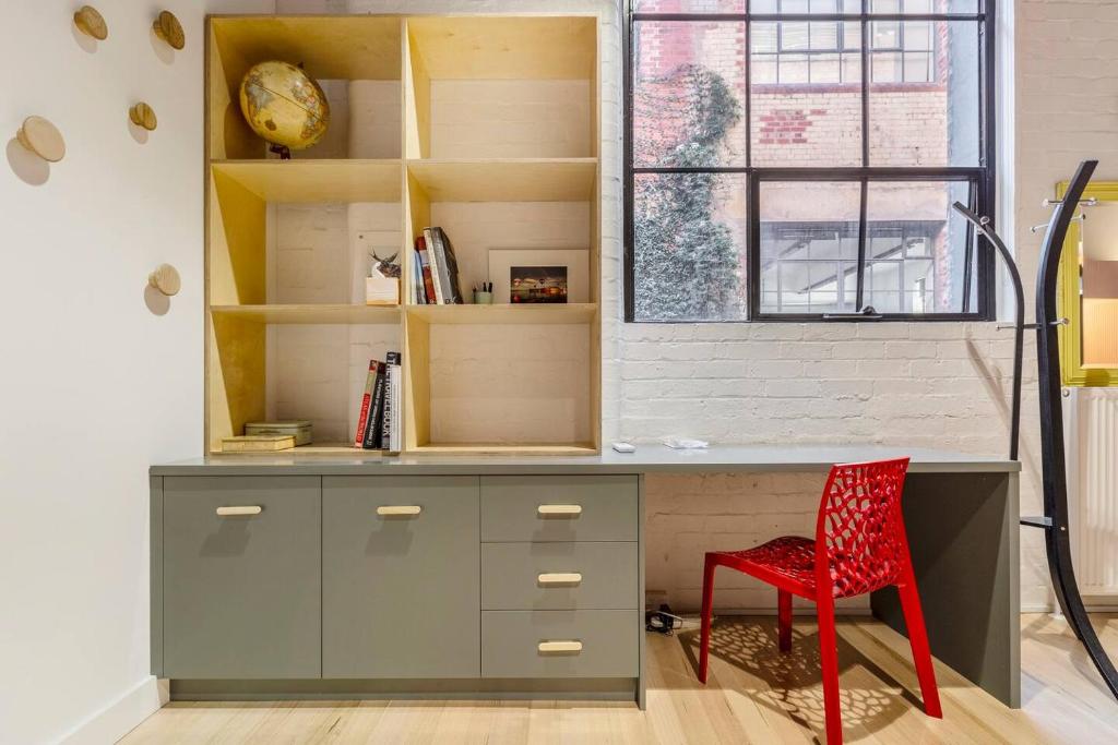 a desk with a red chair in a room at Fitzroy Thrills in MacRobertson Factory Conversion in Melbourne