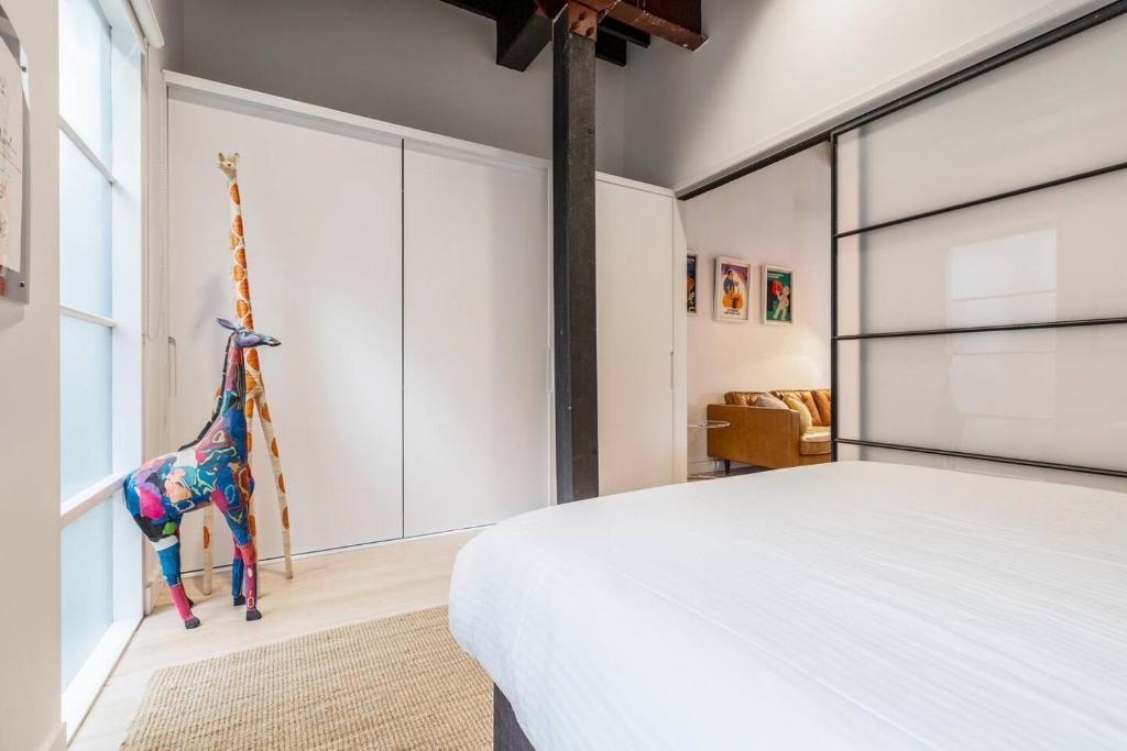 a bedroom with a bed with a toy giraffe on the wall at Fitzroy Thrills in MacRobertson Factory Conversion in Melbourne