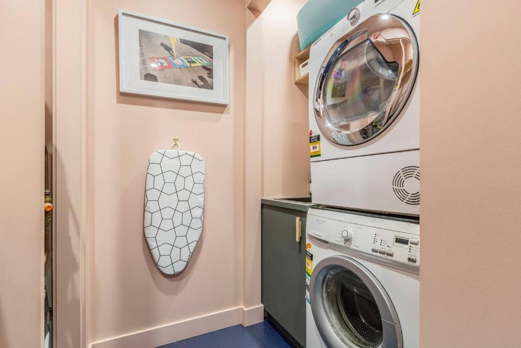 a laundry room with a washer and dryer at Fitzroy Thrills in MacRobertson Factory Conversion in Melbourne