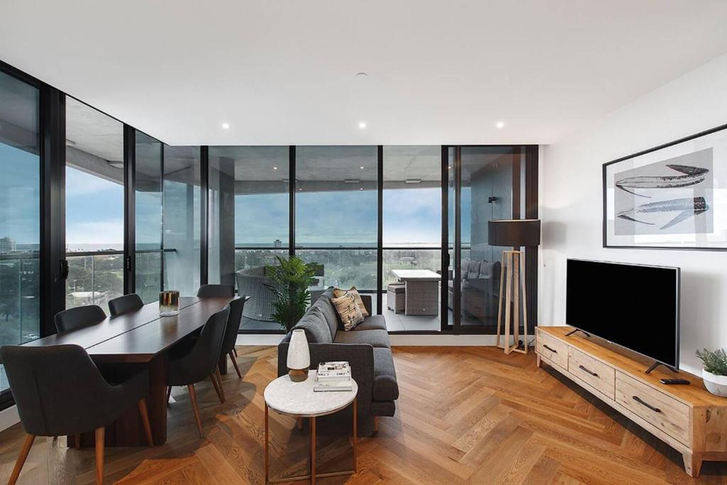 a living room with a couch and a table and a television at Top of Town - Penthouse with Every Opulence in Melbourne