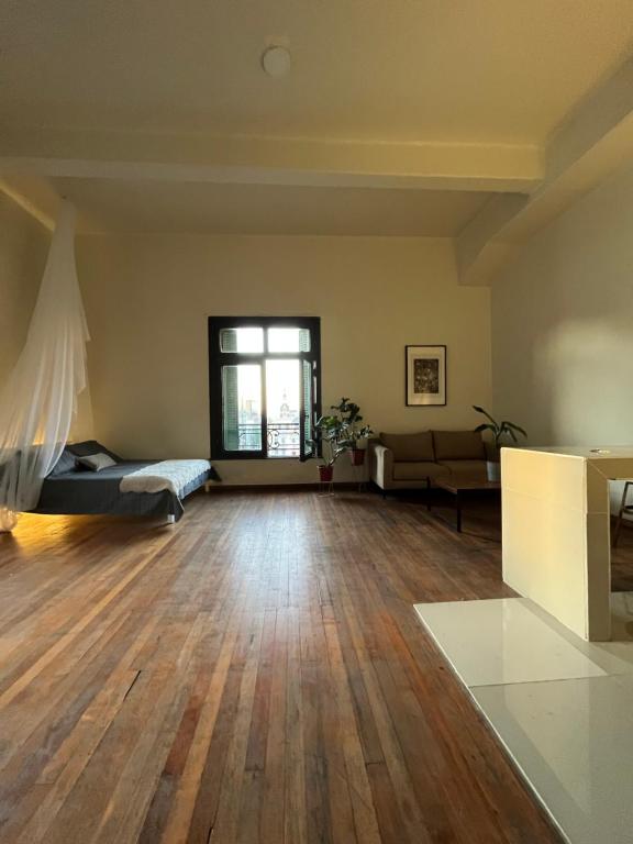een lege woonkamer met een bed en een bank bij Estudio Casco Histórico de Santiago in Santiago