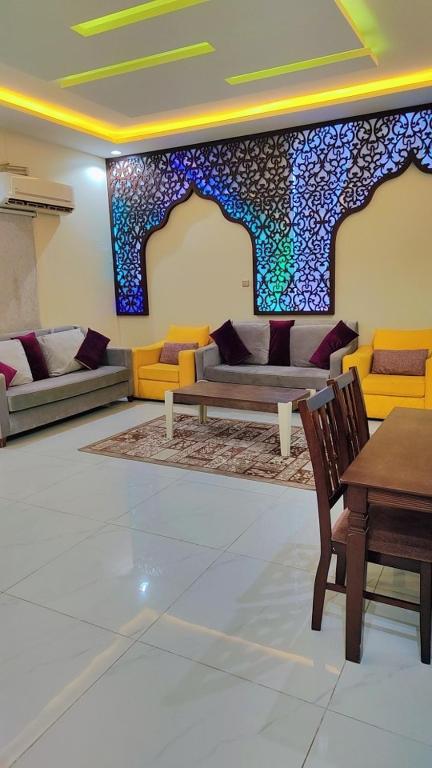 a living room with couches and a table and a wall at شاليهات ستي لاند in Taif