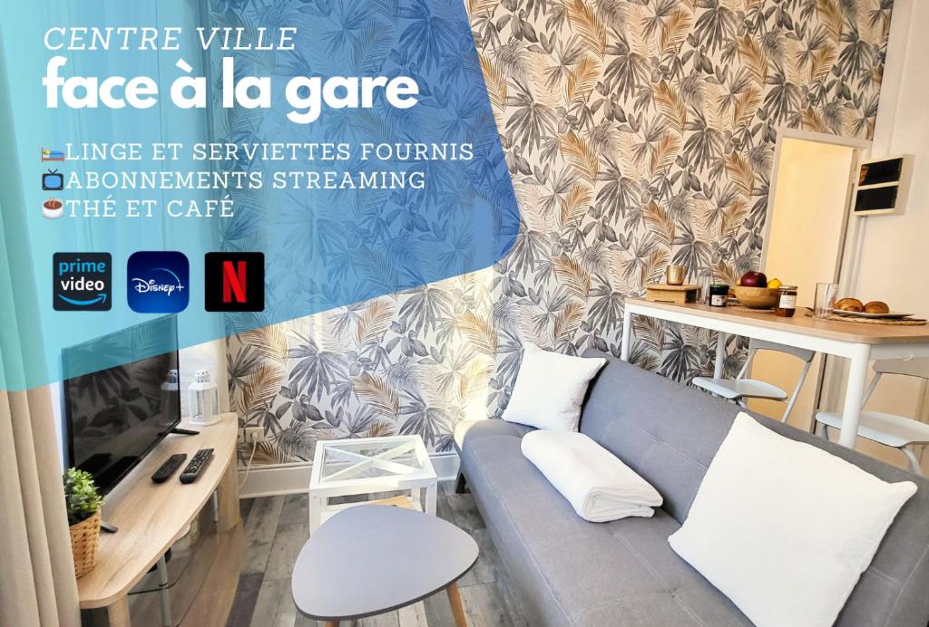 een woonkamer met een bank en een tv bij Appartement Cosy - En face de la gare, au centre ville in Épinal