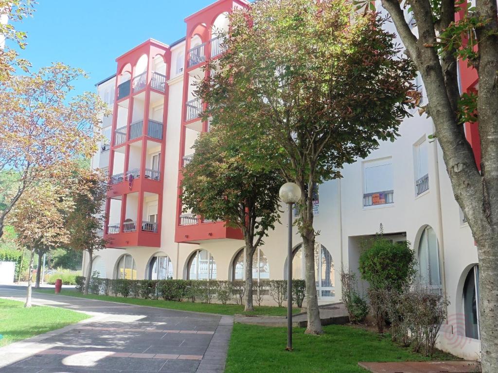 ラマルー・レ・バンにあるAppartement Lamalou-les-Bains, 2 pièces, 2 personnes - FR-1-451-22の目の前に木々が植えられた赤と白の建物