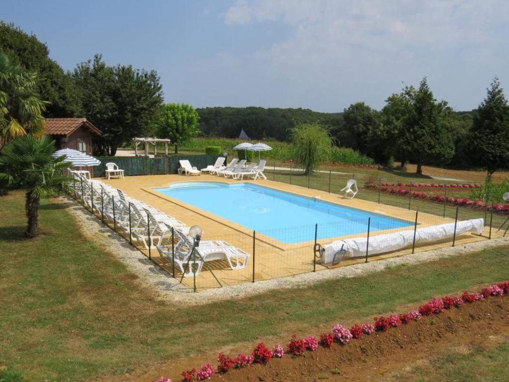 una gran piscina con sillas en Gîte Saint-Crépin-et-Carlucet, 5 pièces, 10 personnes - FR-1-616-108, en Saint-Crépin-et-Carlucet