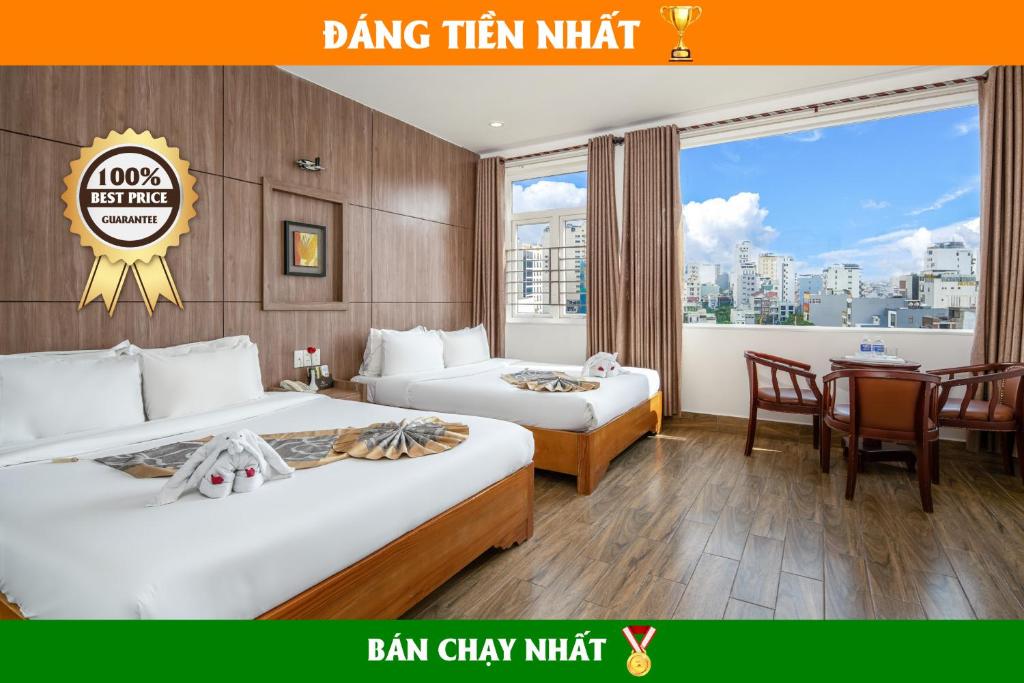 a hotel room with two beds and a table and chairs at Valencia Da Nang Beach Hotel in Danang