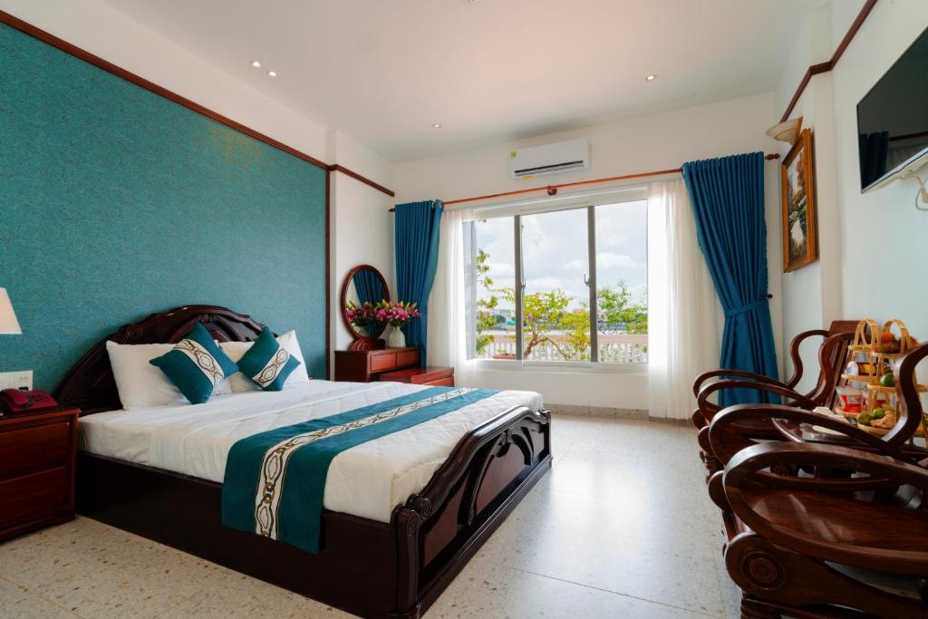 a bedroom with a bed and a large window at CHUONG DUONG HOTEL in Mỹ Tho