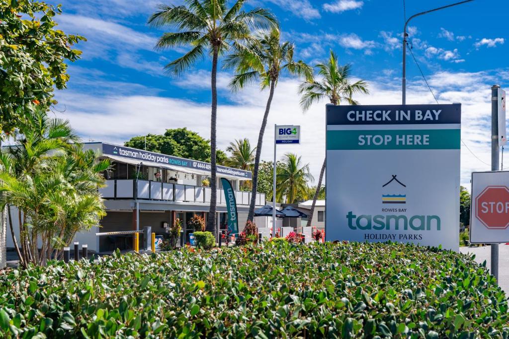 a sign that reads check in bay stop here at BIG4 Tasman Holiday Parks - Rowes Bay in Townsville