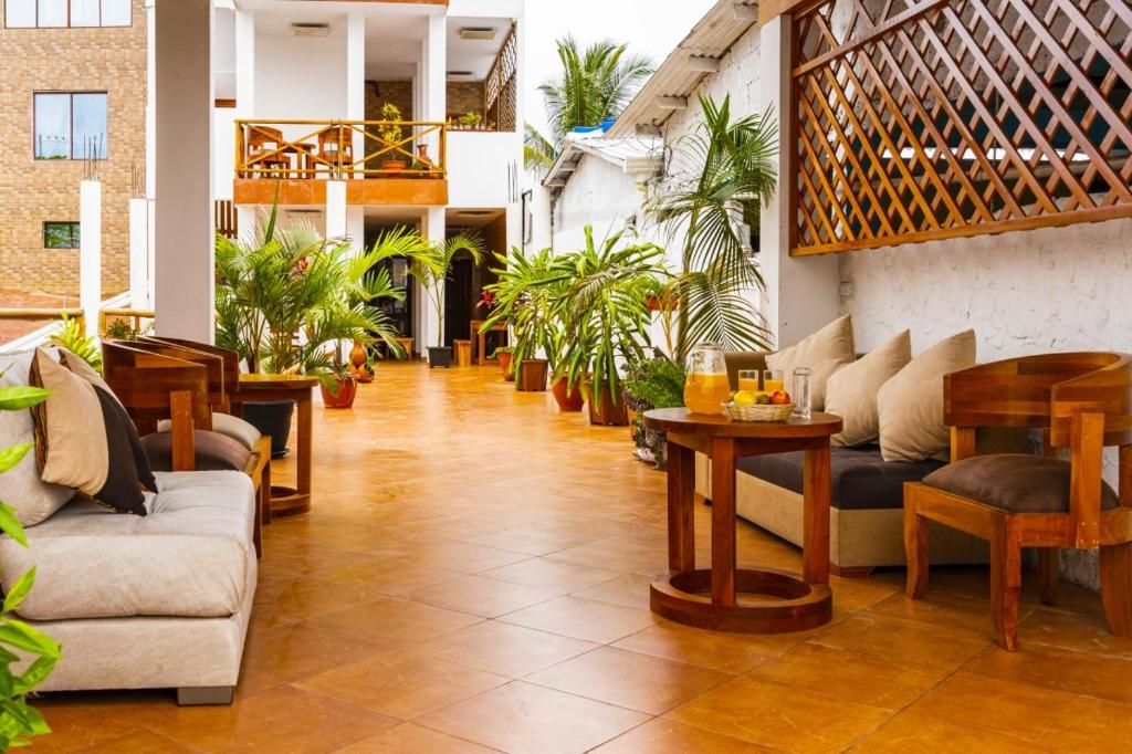 um átrio com sofás, mesas e plantas em EXCLUSIVE CONDO GALAPAGOS & BEYOND 2 em Puerto Ayora