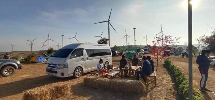a group of people sitting at tables in front of a van at ศรีวิภา​ฮิลล์​แคมป์ปิ้ง in Ban Thung Samo