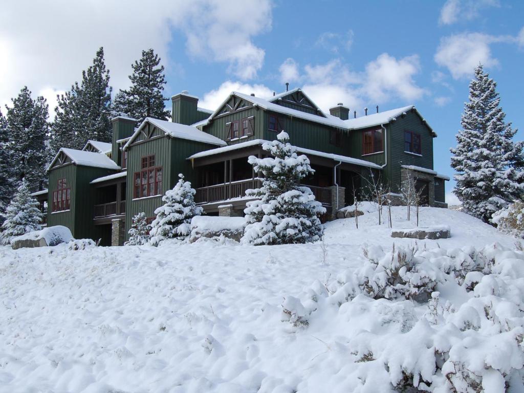 una grande casa verde con la neve davanti di Snowcreek Resort Vacation Rentals a Mammoth Lakes