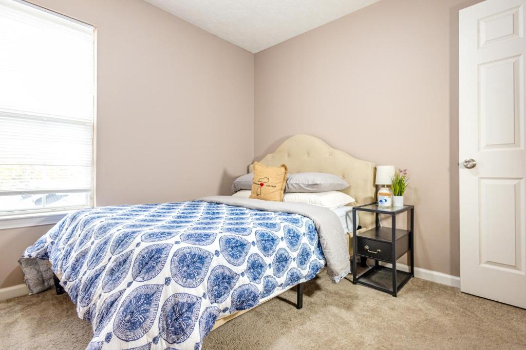 a bedroom with a bed with a blue and white comforter at LUX - Downtown Oasis - Pool Table! Free Parking! in Lexington