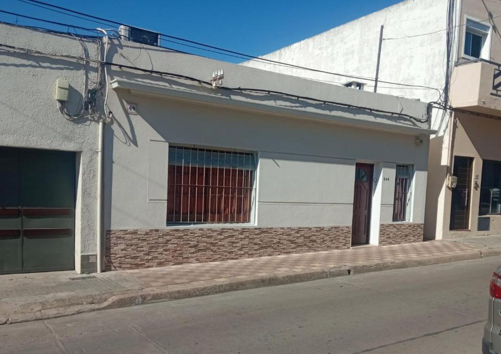 un edificio blanco al lado de una calle en La Casa de los Viejos, en Minas