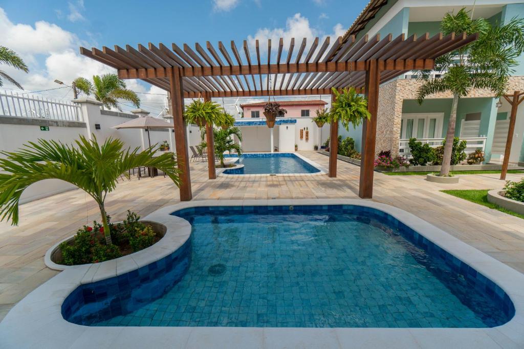 a swimming pool in a backyard with a pergola at Pousada Diane in Trairi