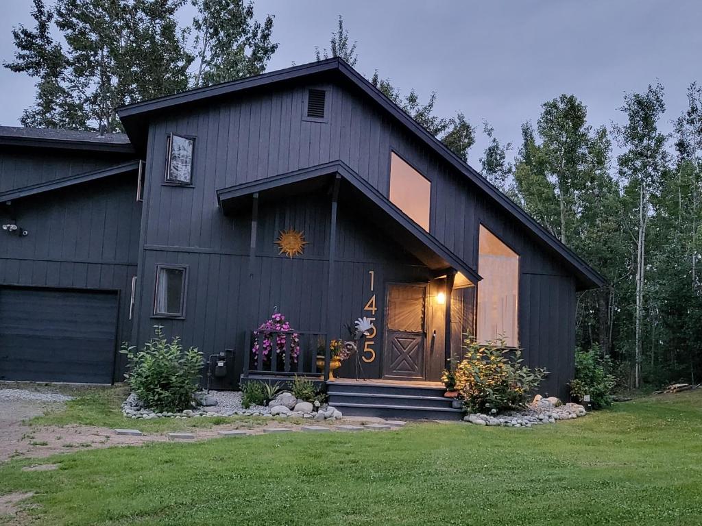 um celeiro preto com uma grande porta de madeira em Moose Valley Inn em Palmer