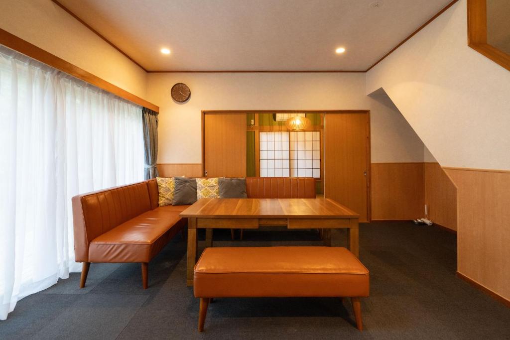una sala de estar con una mesa y un sofá en S-villa Nasu 5th, en Nasu